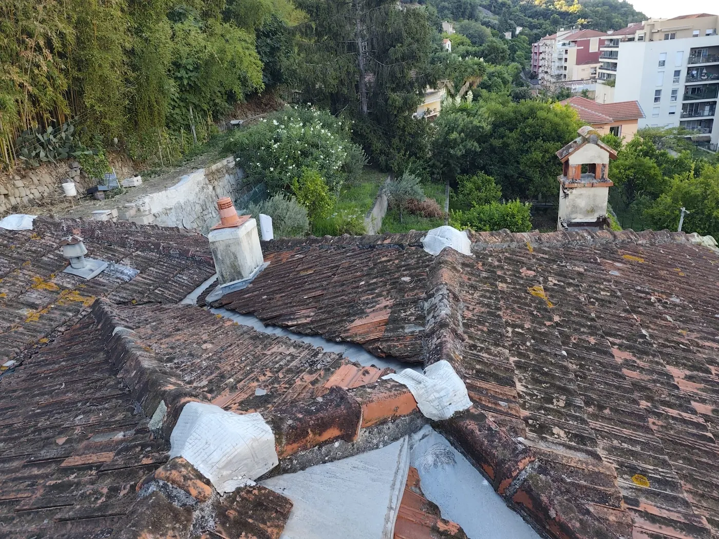 Ancienne toiture en tuiles abîmée et couverte de mousse avant rénovation